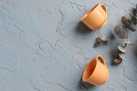 Teapot with cups for baby and eucalyptus branch on grunge gray backgroundの写真素材