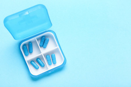 Container with pills on blue backgroundの写真素材