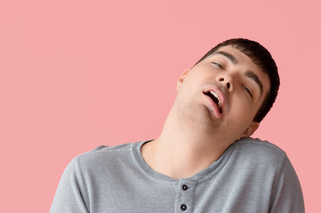 Young man on pink background, closeup. National Cerebral Palsy Awareness Month