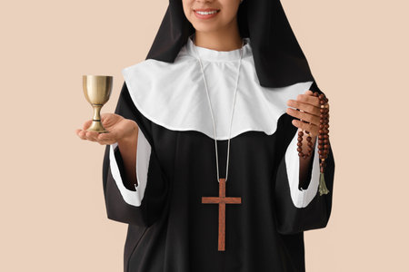Young nun with chalice and rosary beads on beige background