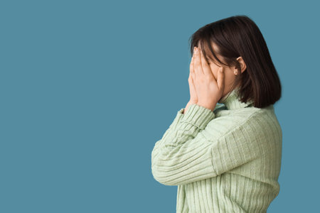 Beautiful young stressed woman on blue background. Stress Awareness Monthの写真素材