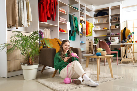 Female tailor knitting on floor in atelierの写真素材
