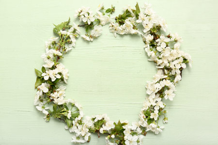Frame made of beautiful blossoming branches on green wooden backgroundの写真素材