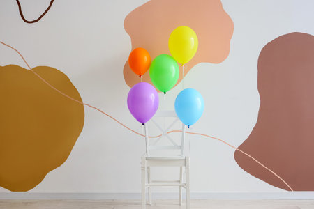 Chair with colorful floating balloons at homeの写真素材