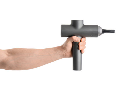 Young man with percussive massager on white backgroundの写真素材