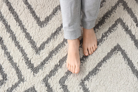 Barefoot woman on carpet at home, top viewの写真素材