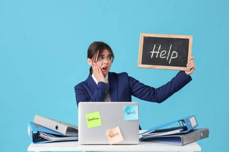 Young stressed businesswoman holding laptop and chalkboard with word HELP on blue background. Stress...
