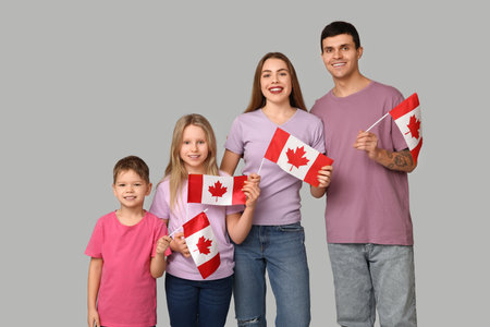 Beautiful family with flags of Canada on gray backgroundの写真素材