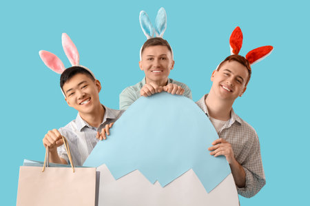Young men in bunny ears with shopping bags and paper egg on blue background. Easter Sale