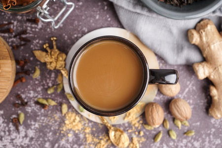 Cup of tasty masala tea with different spices on grunge background, closeupの写真素材