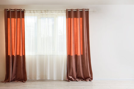 Red curtains on large window in empty living roomの写真素材