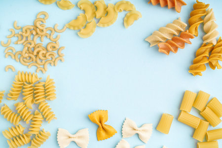 Frame made of different uncooked pasta on blue backgroundの写真素材