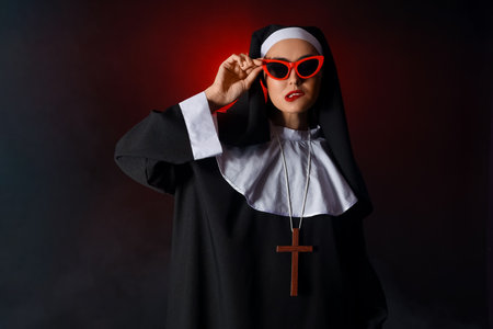 Naughty nun in sunglasses on dark backgroundの写真素材