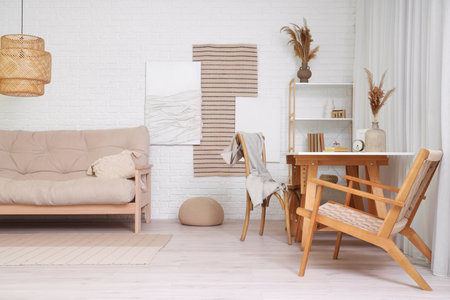 Interior of stylish living room with paintings, sofa and workplaceの写真素材