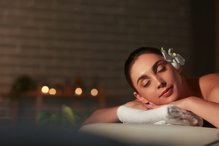 Young woman relaxing in dark spa salon, closeup