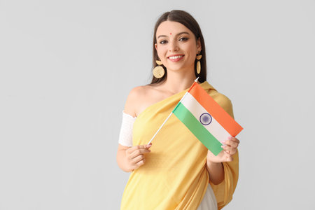 Young woman with Indian flag on light backgroundの写真素材
