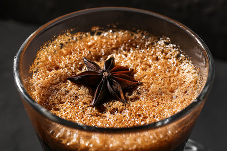 Glass of delicious espresso with star anise on dark background, closeupの写真素材