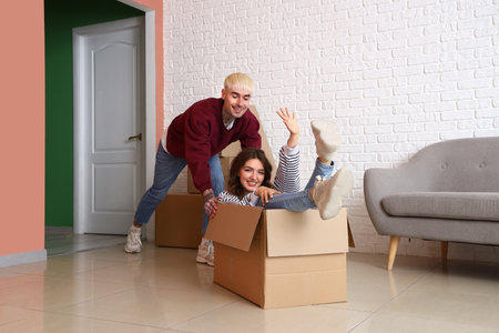 Young couple having fun in room on moving dayの写真素材