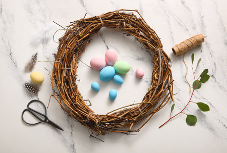 Supplies for creating Easter wreath with painted eggs on grunge white backgroundの写真素材