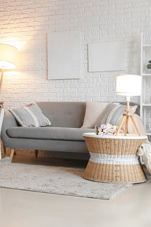 Interior of living room with cozy gray sofa and glowing lampsの写真素材