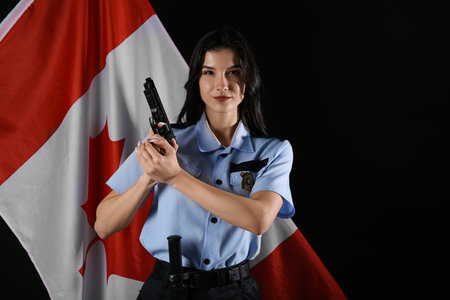 Female police officer with gun and flag of Canada on black backgroundの写真素材