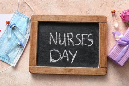 Chalkboard with text NURSES DAY, gift box and ampules on beige grunge backgroundの写真素材
