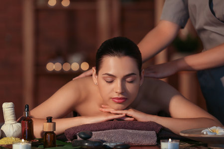 Young woman getting massage in dark spa salon, closeupの写真素材