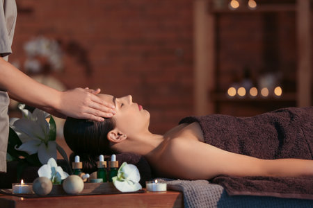 Young woman getting massage in dark spa salon, closeupの写真素材