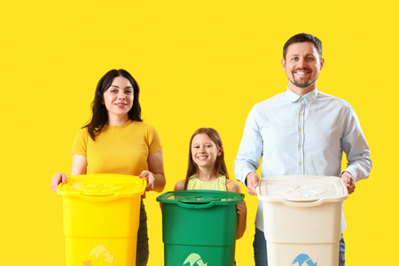 Family with recycle bins on yellow backgroundの写真素材