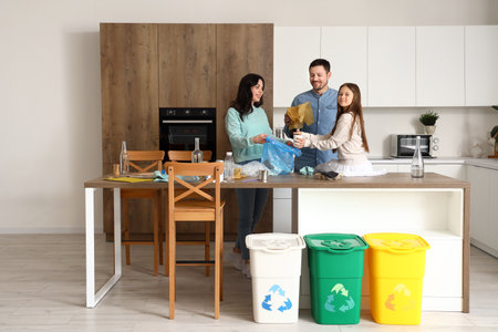 Family sorting garbage in kitchenの写真素材