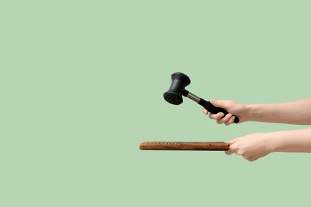 Woman with meat hammer and board on green backgroundの写真素材