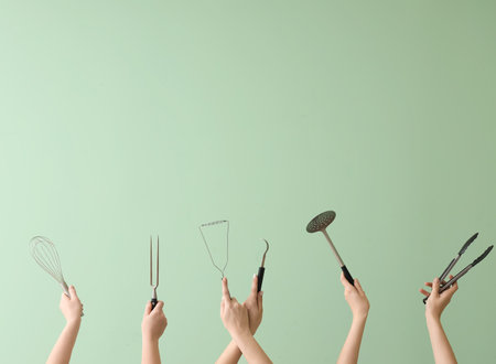 Women with kitchen utensils on green backgroundの写真素材