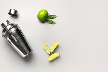 Shaker with fresh limes and leaves on gray backgroundの写真素材