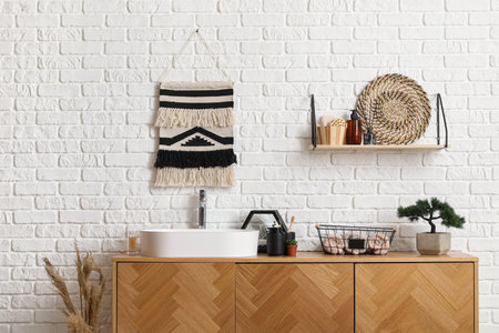 Sink bowl, bath accessories and bonsai tree on wooden cabinet in bathroomの写真素材
