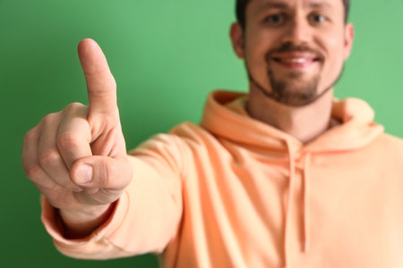 Handsome man using virtual screen on green background, closeupの写真素材