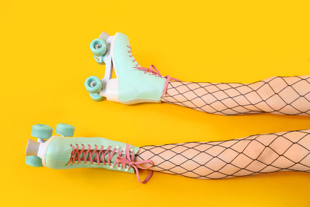Legs of woman in roller skates on yellow backgroundの写真素材