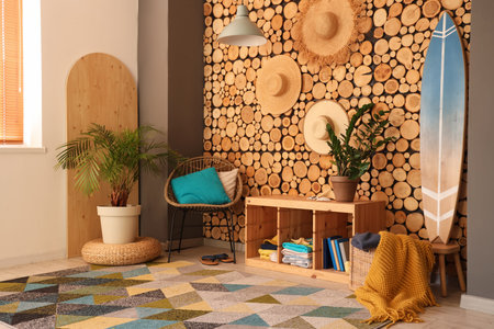 Stylish interior of living room with armchair and surfboard. Summer composition