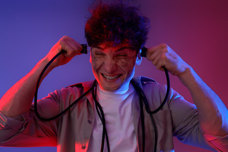 Electrocuted young man with burnt face and plugs on dark background, closeupの写真素材