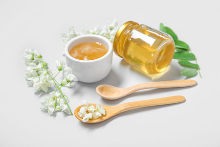 Composition with sweet honey and acacia flowers on white backgroundの写真素材