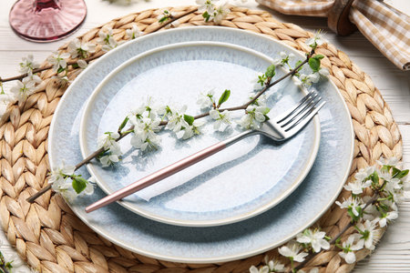 Beautiful table setting with blossoming branches on white wooden backgroundの写真素材