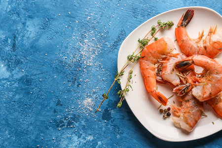 Plate with tasty boiled shrimps on blue backgroundの写真素材