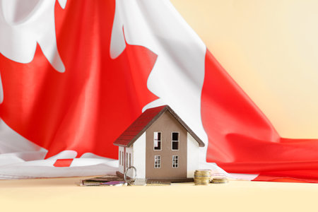 Figure of house, keys, money and Canadian flag on color backgroundの写真素材