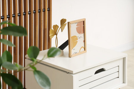 Photo frame on coffee table, houseplant and folding screen in stylish roomの写真素材
