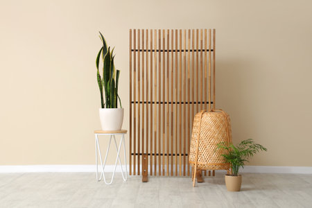 Beautiful interior of room with coffee table, houseplant, rattan basket and folding screenの写真素材