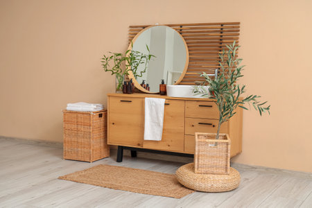 Interior of light bathroom with chest of drawers, sink and mirrorの写真素材