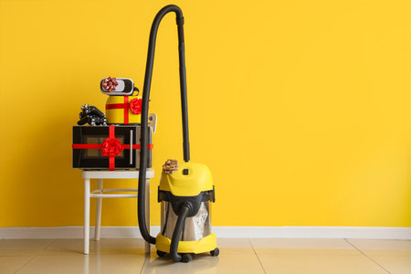Different appliances with gift bows near yellow wallの写真素材