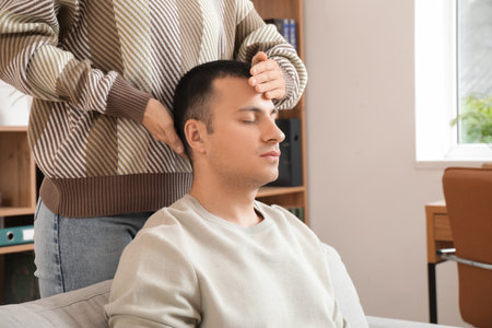 Female psychologist hypnotizing man in officeの写真素材