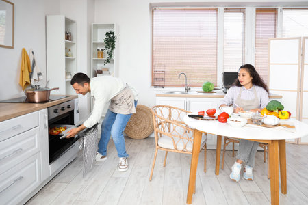 Young couple baking vegetables in kitchenの写真素材