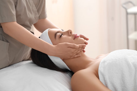 Beautiful woman getting facial massage in salon, closeupの写真素材