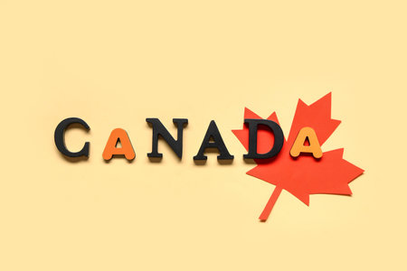 Maple leaf and word CANADA on yellow background. Canada Day conceptの写真素材